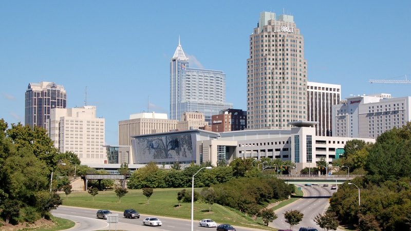 city of raleigh skyline image with cars on south saunders street
