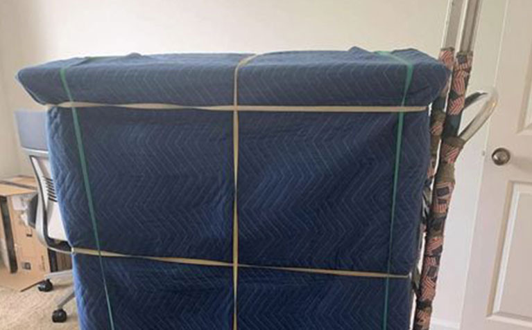 Carefully packed moving boxes and protected furniture